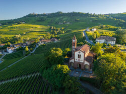 Veduta aerea chiesa con vigneti delle Langhe, La Morra sullo sfondo, territorio del Barolo, Piemonte