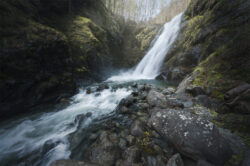 Cascata a più livelli che si tuffa in un torrente alpino sassoso in lunga esposizione, fotografia di territorio piemontese di Carlo Pagliuca