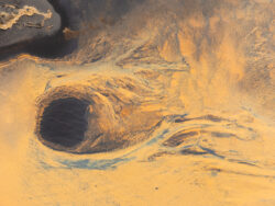 Fotografia zenitale di specchi d'acqua su sabbia nera vulcanica, geometrie naturali e riflessi nel paesaggio selvaggio islandese