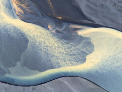 Texture astratta di fiumi glaciali che si intrecciano su sedimenti lavici, ripresa aerea zenitale di fotografia di territorio d'autore