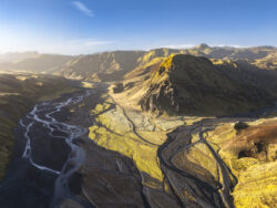 Veduta dall'alto di acque scure che lambiscono formazioni rocciose basaltiche nell'entroterra islandese, fotografia di paesaggio crudo