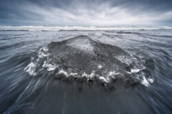 Blocco di ghiaccio trasparente sulla spiaggia nera Diamond Beach in Islanda, dettaglio in lunga esposizione di Carlo Pagliuca